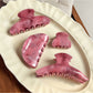 Beau pink ombre hair claw clip on white background showing gradient color