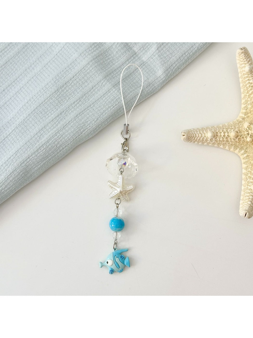 Mini fish keychain in red color shown on a keyring with keys