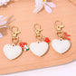 Close-up of red heart shaped bag charm keychain showing gold clasp and stitching details