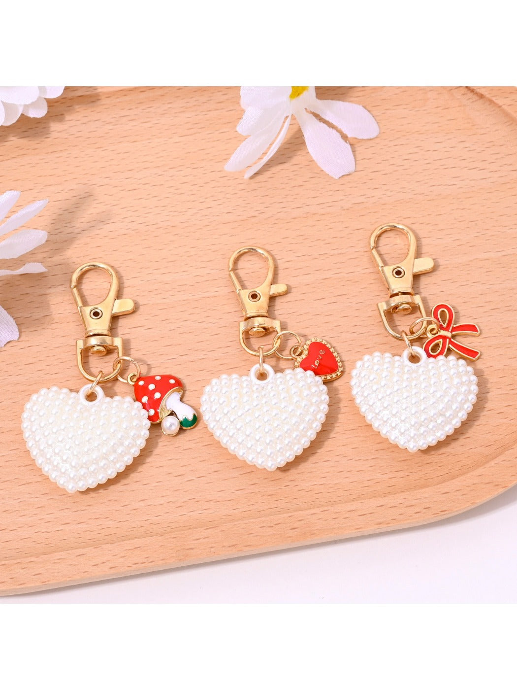 Close-up of red heart shaped bag charm keychain showing gold clasp and stitching details