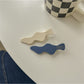 Beau blue and white hair clip styled in long brown hair