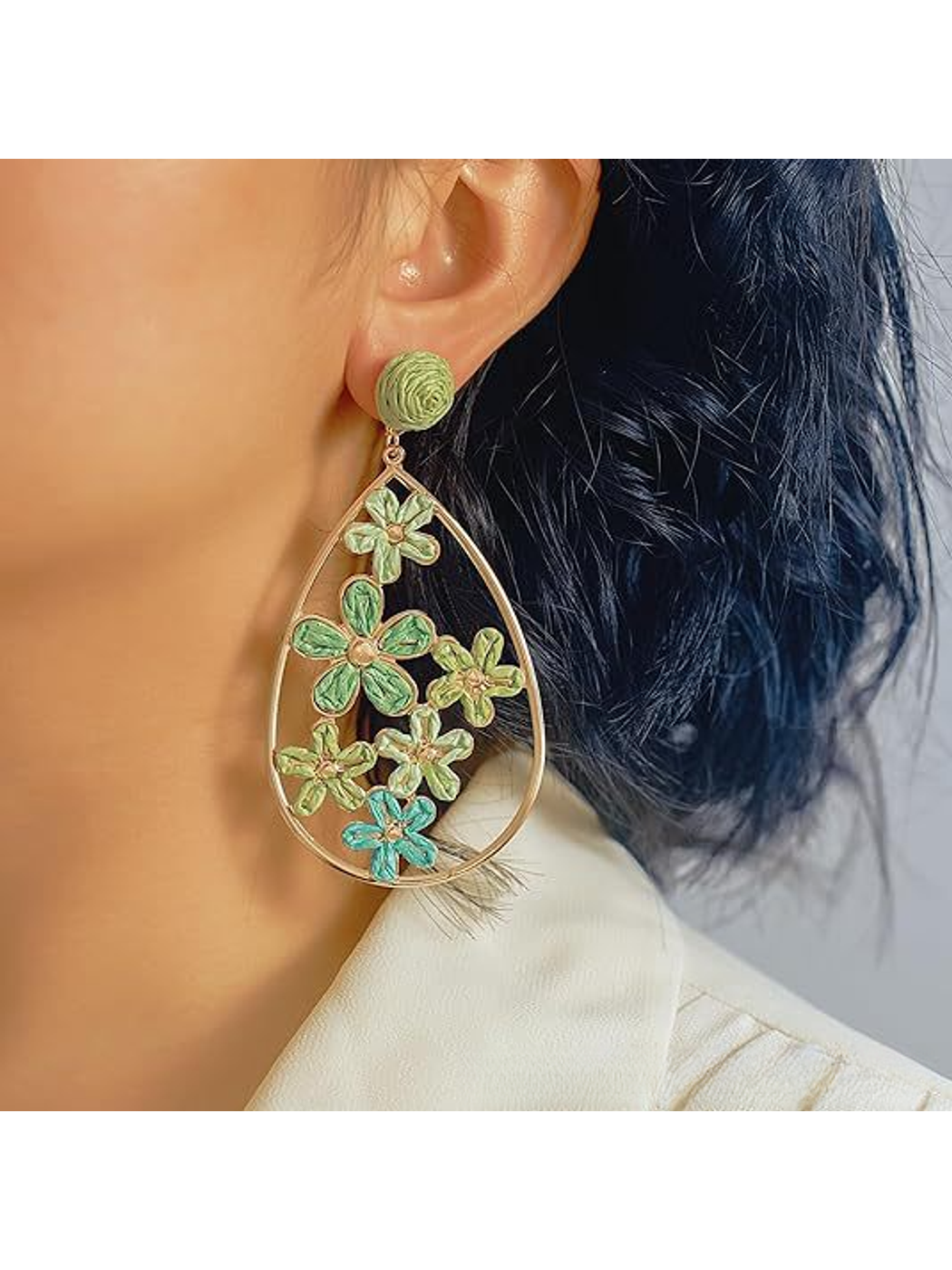 Earedge floral raffia drop earrings displayed hanging on a jewelry stand