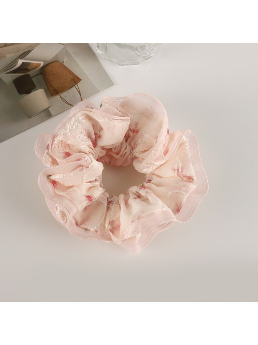 Gifty scrunchie worn on a wrist, showcasing its delicate floral design and ruffles