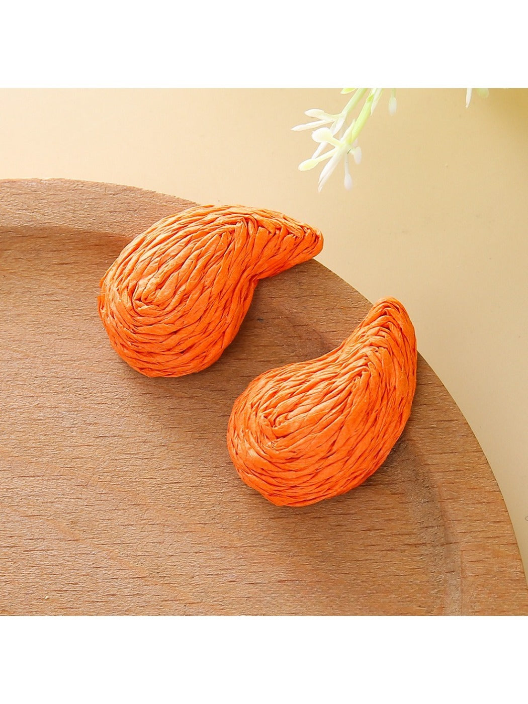 Pair of raffia water drop shaped stud earrings with natural fiber texture