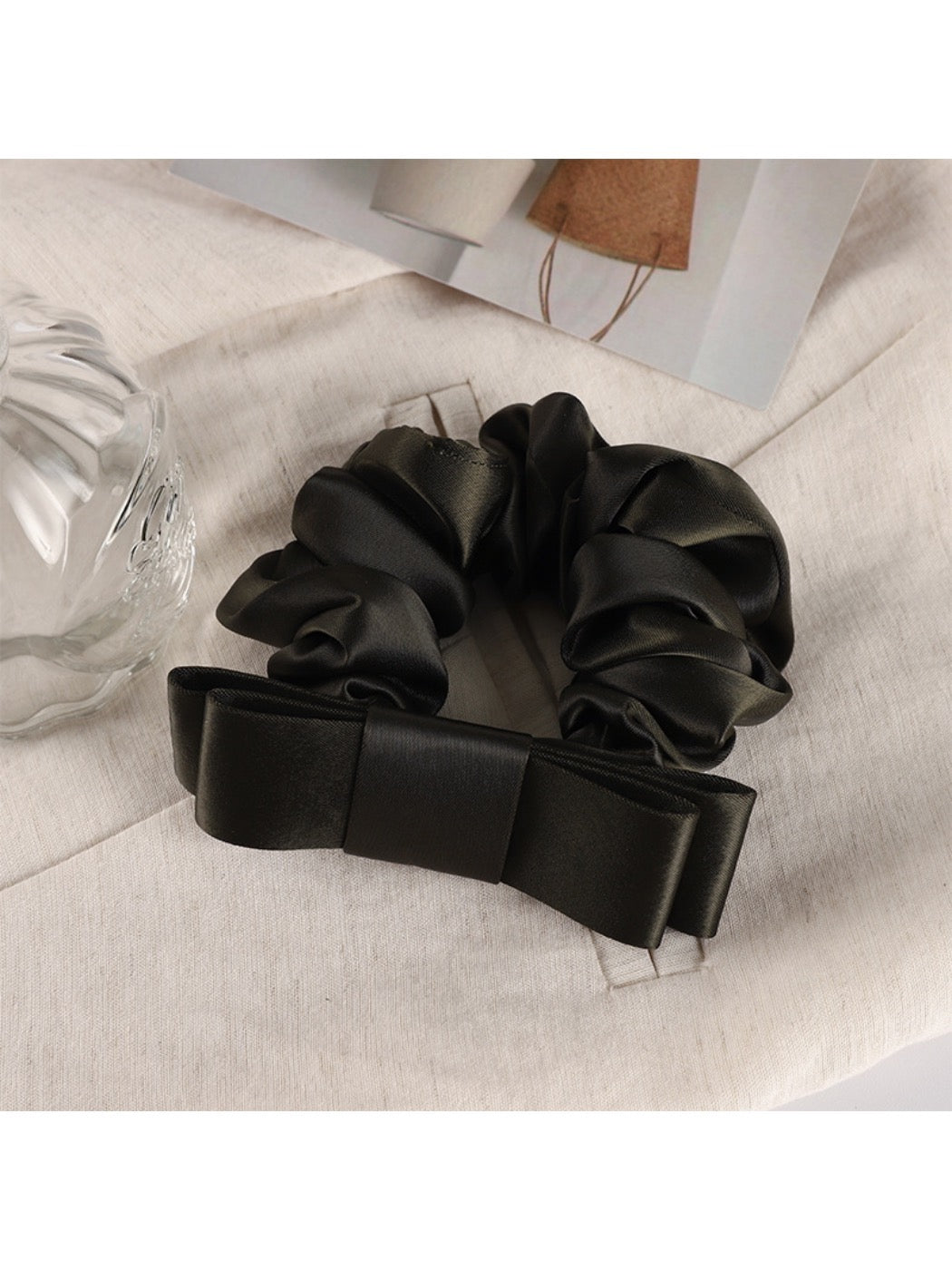 Soft fabric scrunchie with gentle gathers and romantic floral charm detail