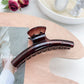 Pastel curved claw clip open showing inner teeth and clasp details