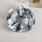 Gifty pastel scrunchie in multiple pastel shades arranged in a flat lay