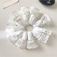 White lace trim scrunchie displayed with soft natural lighting