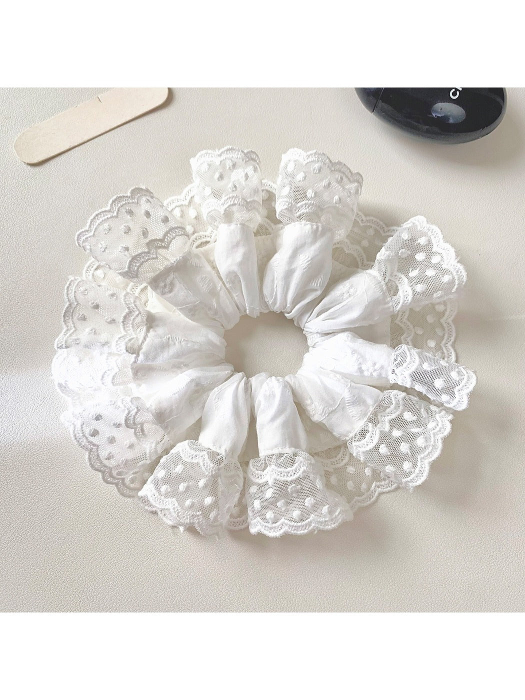 White lace trim scrunchie displayed with soft natural lighting