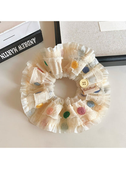 Side view of ruched scrunchie with bright polka dot pattern