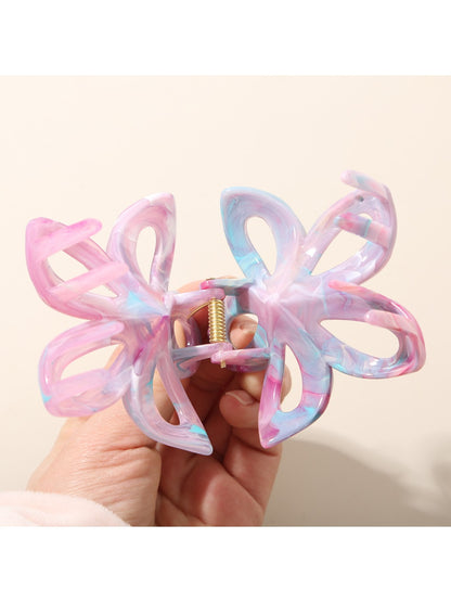 Beau hair clip clipped onto brown hair, displaying colorful flower design