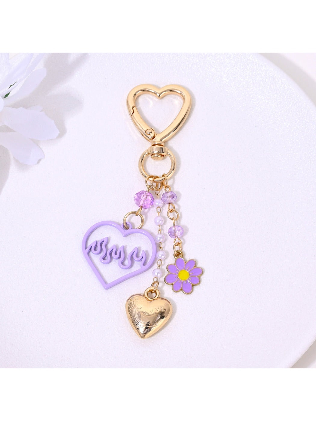 Close-up of heart shaped charm with intricate flower design on keychain
