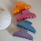 Close-up of Beau hair clip showing multicolored polka dots on acetate material