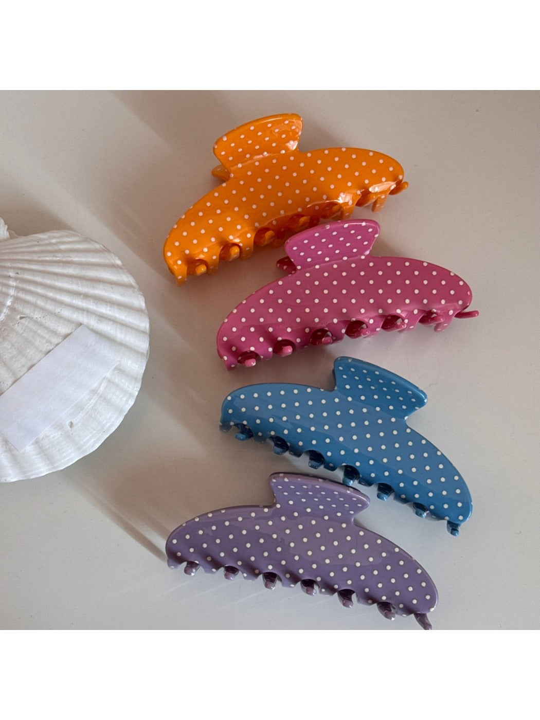 Close-up of Beau hair clip showing multicolored polka dots on acetate material