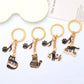 Side view of cartoon cat piano keychain showing keyring attachment