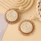 Earedge colorful raffia earrings hanging on a jewelry stand