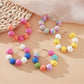 Close-up of Earedge vintage raffia round ball drop earrings on white background