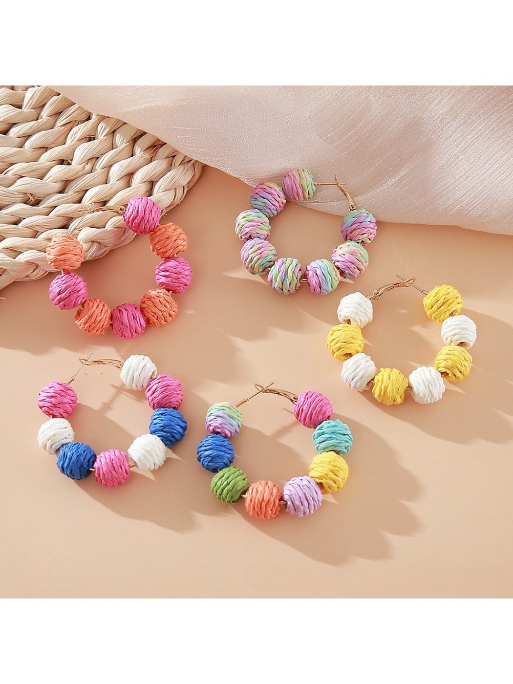Close-up of Earedge vintage raffia round ball drop earrings on white background
