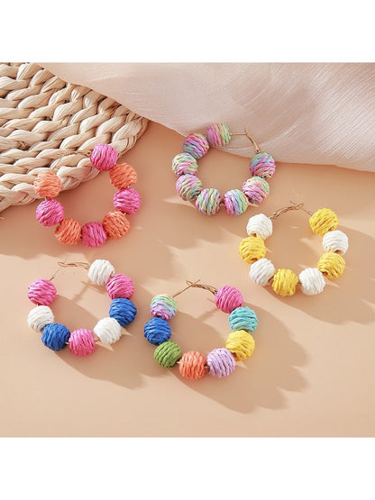 Close-up of Earedge vintage raffia round ball drop earrings on white background