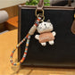 Close-up of trendy cat charm keychain with silver ring on white background