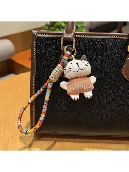 Close-up of trendy cat charm keychain with silver ring on white background