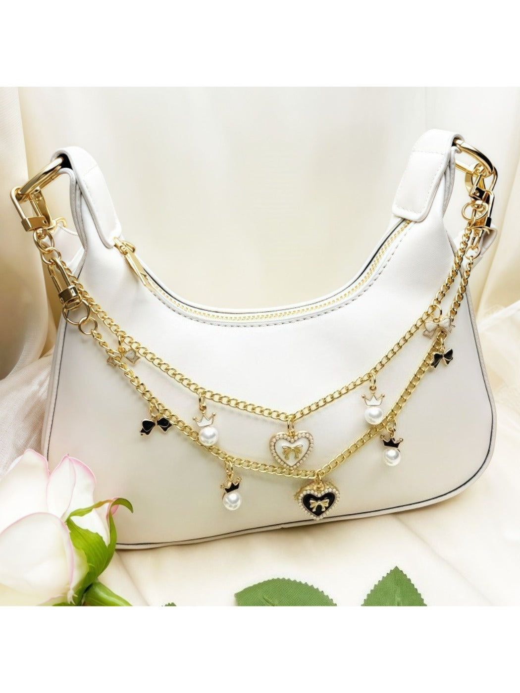 Minimalist heart-shaped bow pendant bag charm in soft pink leather with gold hardware