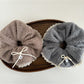 Top view of white lace bow tie scrunchie showing delicate lace pattern