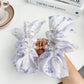 Beau hair claw clip held in hand to show size and floral print details