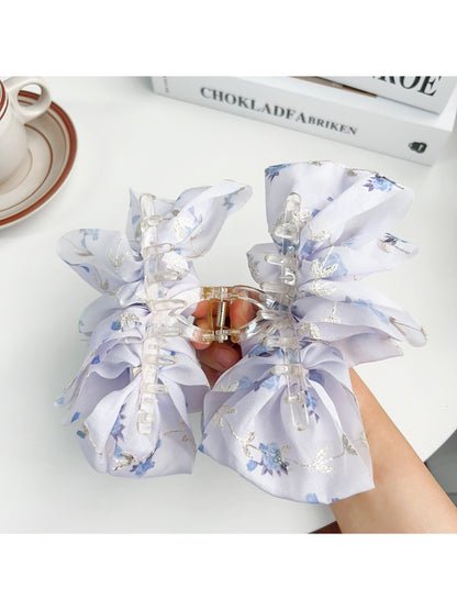 Beau hair claw clip held in hand to show size and floral print details