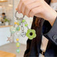 Close-up of Keypus cute green beaded keychain with smiling face charm
