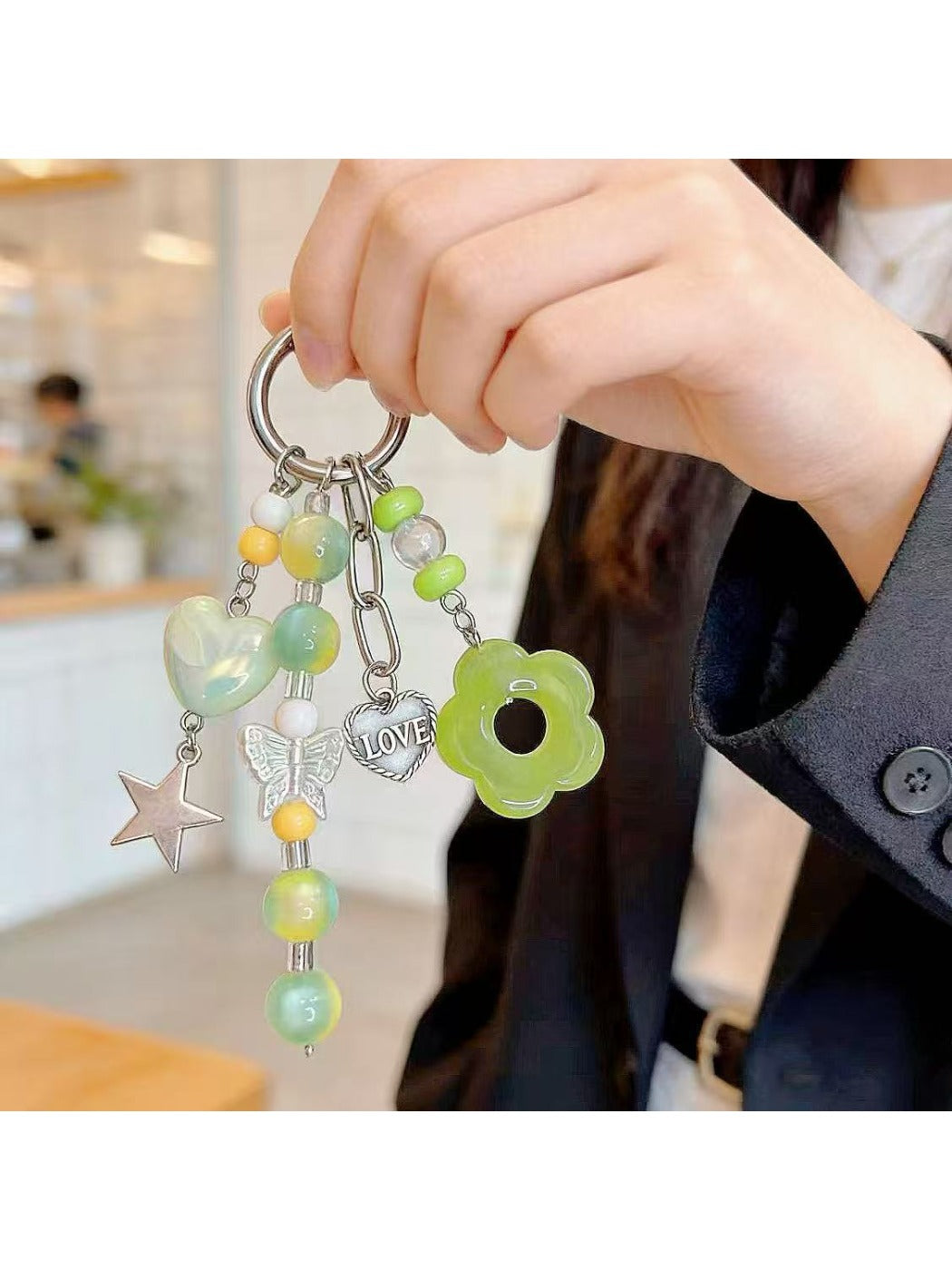 Close-up of Keypus cute green beaded keychain with smiling face charm