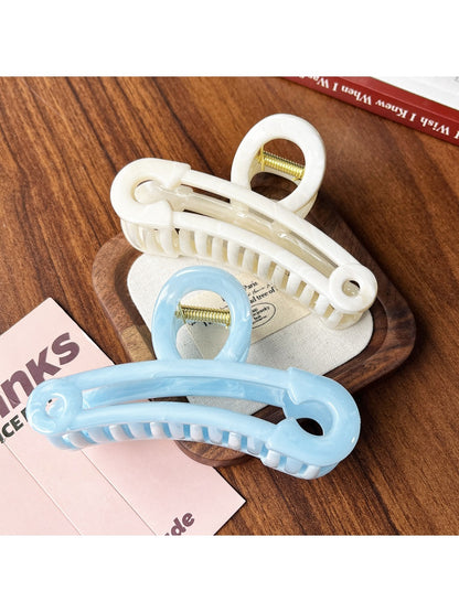 Close-up of Beau gold paperclip claw clip showing hollow design and clasp mechanism