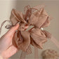 Gifty scrunchie displayed on a white background emphasizing bow and elastic