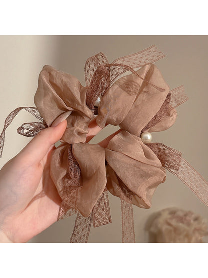 Gifty scrunchie displayed on a white background emphasizing bow and elastic