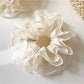 Gifty tulle scrunchie wrapped around a ponytail on a model with blonde hair