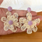 Close-up of earring hook and raffia flower detail on drop earrings