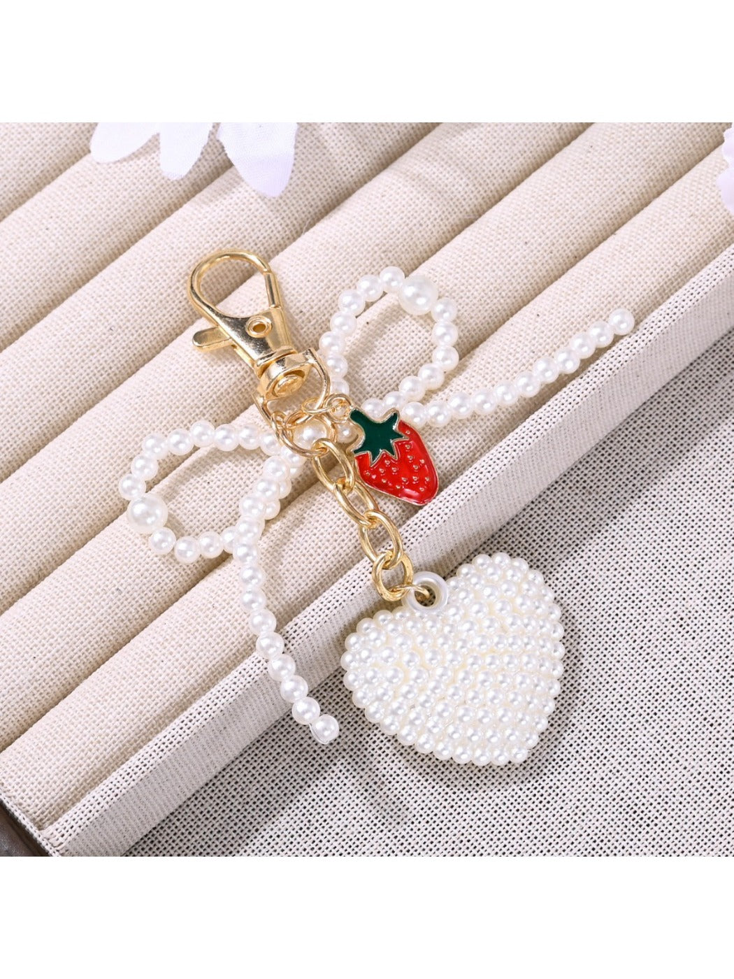 Side view of pink bow heart shaped keychain with gold keyring