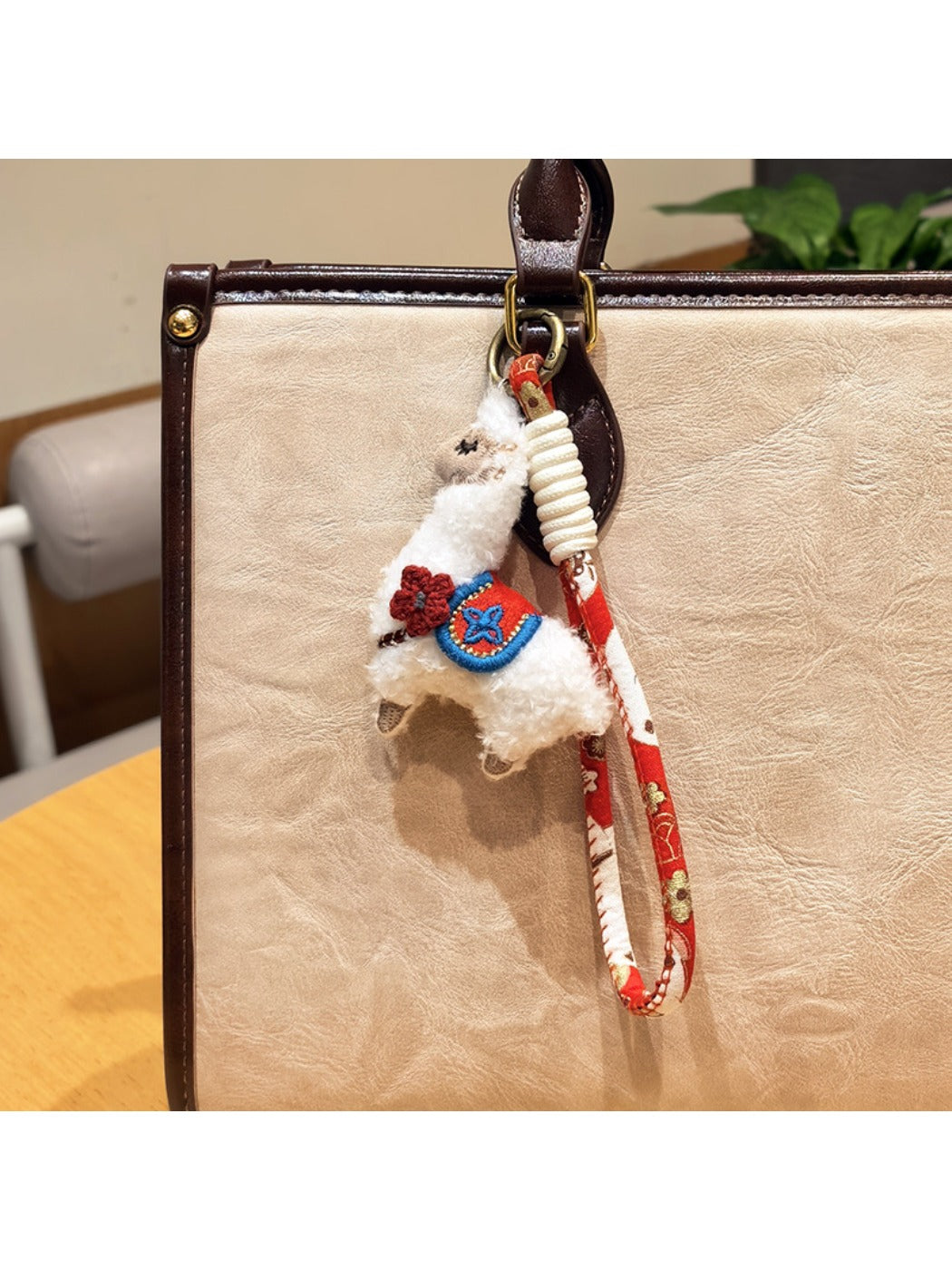 Alpaca keychain held in a hand to show its size and softness