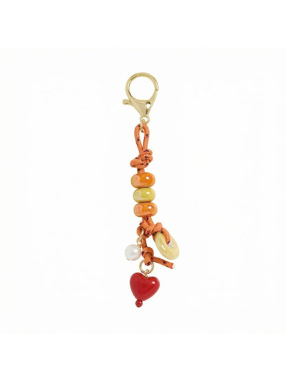 Keypus vintage beaded bag charm attached to a handbag handle