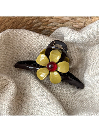 Beau flower-shaped claw clip held in hand to show size and scale