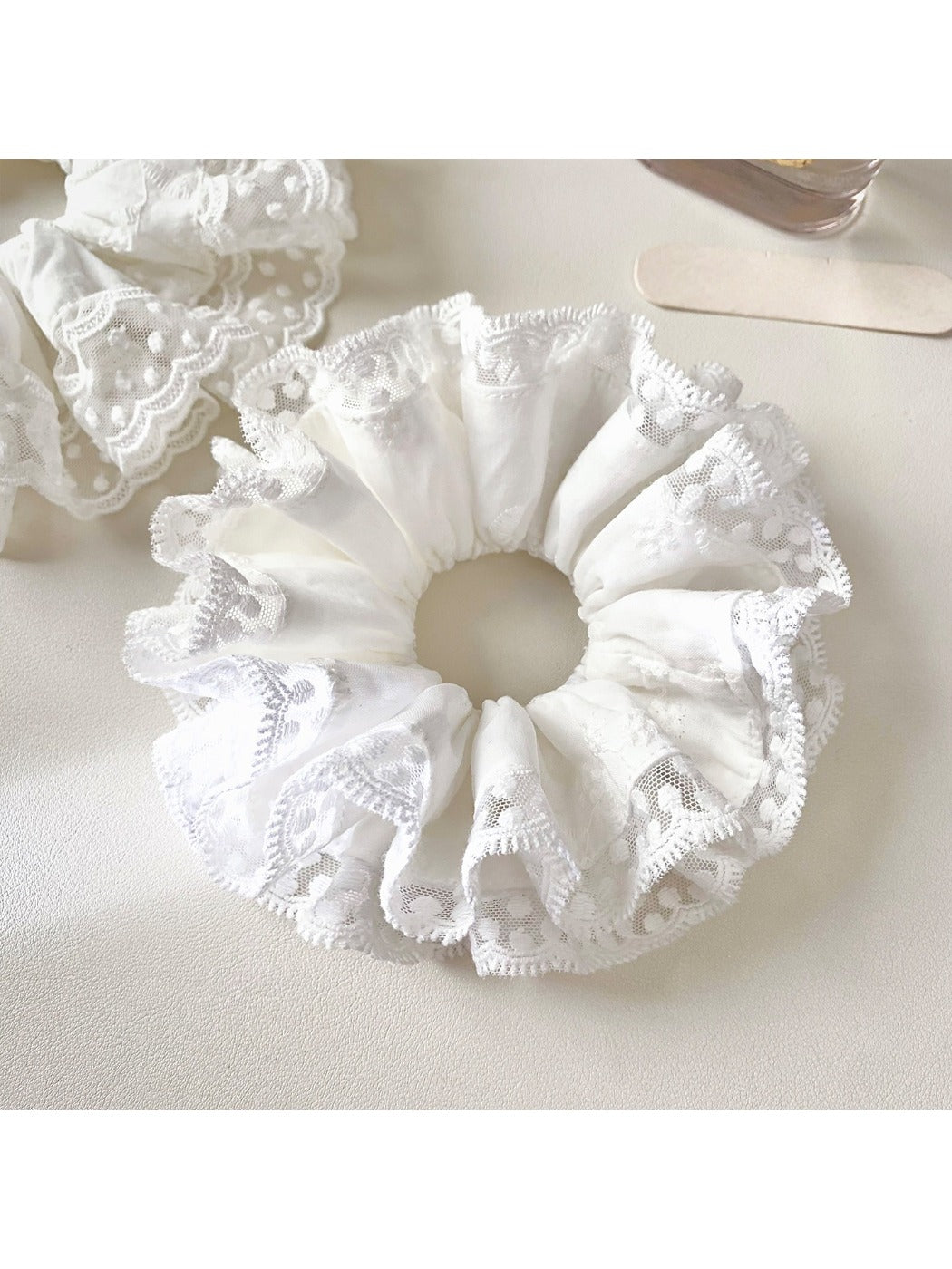 Close-up of white lace trim detail on the Gifty scrunchie