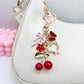 Cherry bow charm keychain hanging from a silver keyring on a white background