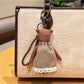 Cartoon bear charm keychain hanging from a backpack zipper pull