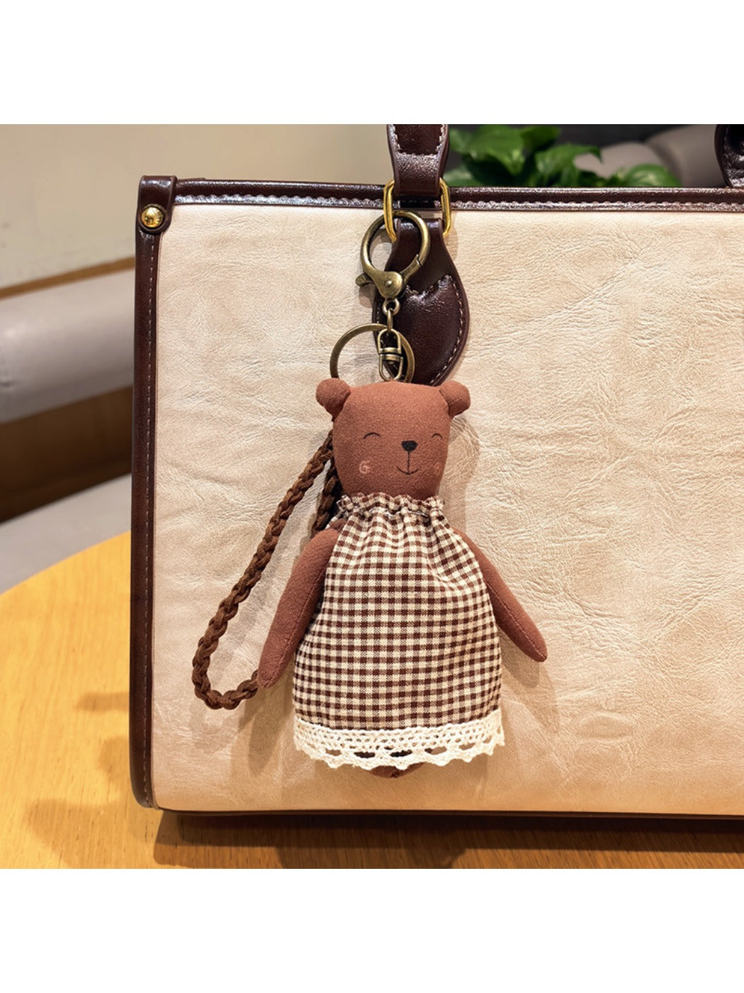 Cartoon bear charm keychain hanging from a backpack zipper pull