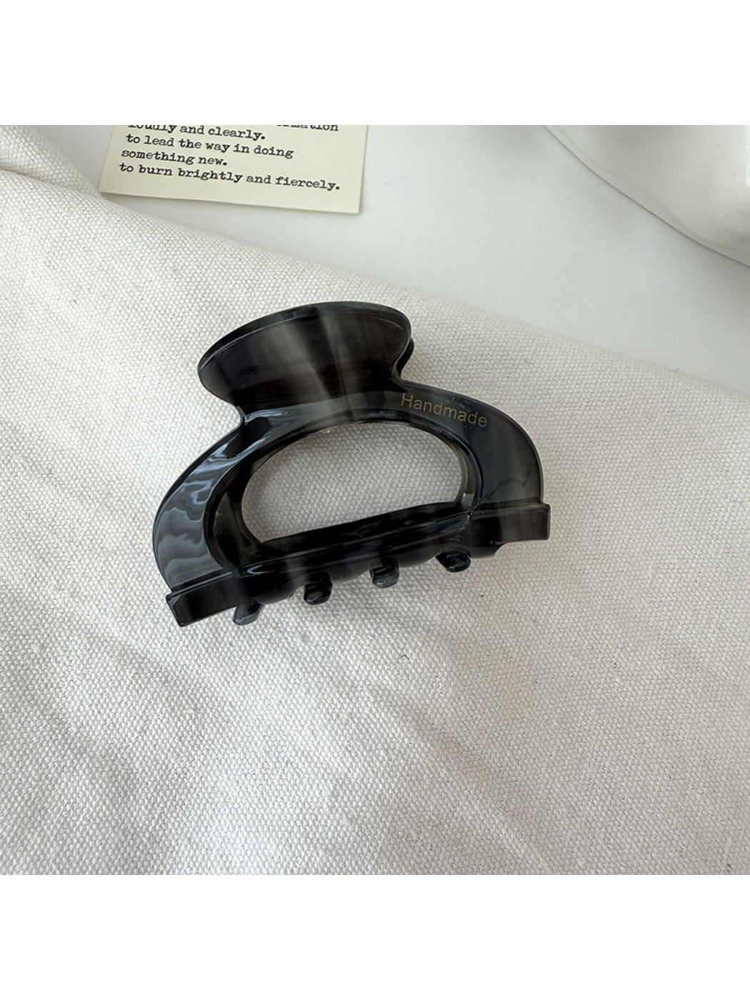 Beau claw clip held in hand to show size and semi circular openwork design