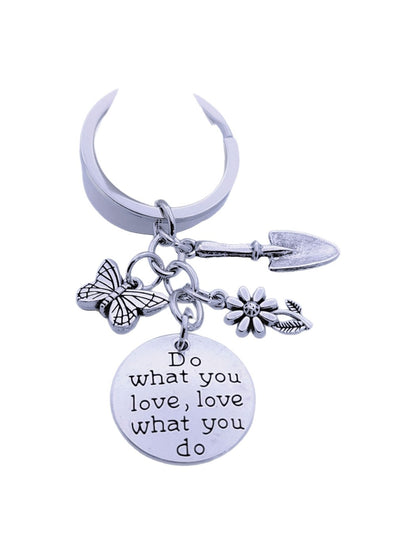 Butterfly flower keychain hanging from a bag zipper with natural light