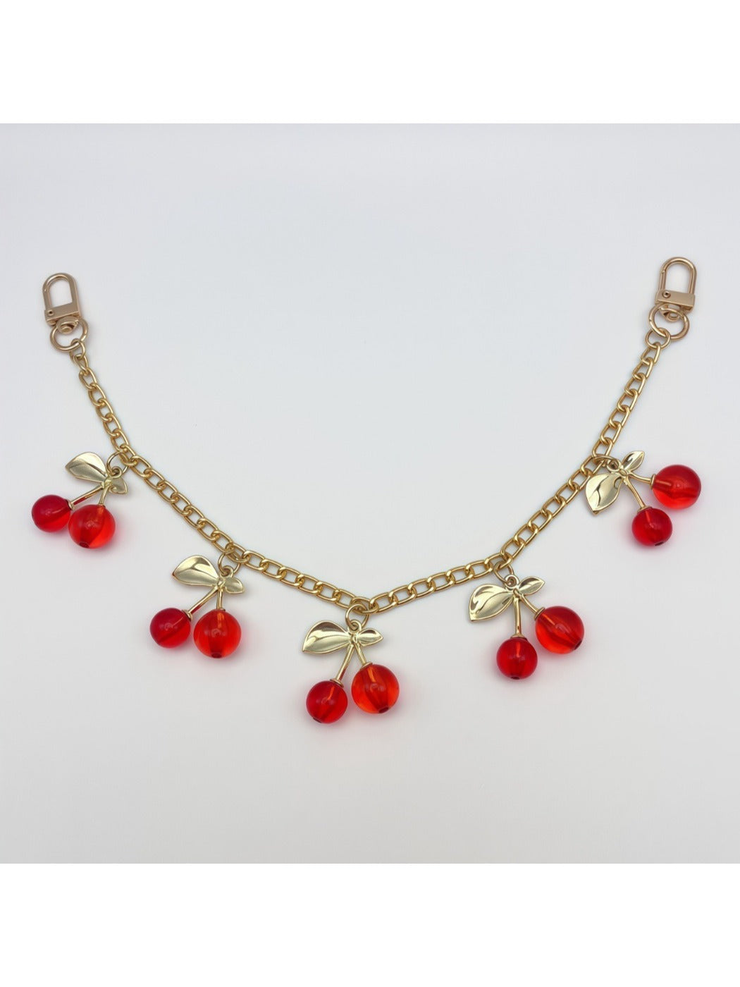 Close-up of the cherry charm’s metal keyring and enamel details