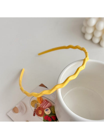 Top view of Gifty solid color wavy headband showing smooth fabric finish