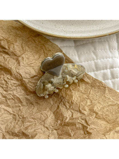 Beau heart shaped acetate claw clip displayed on a flat surface with natural lighting