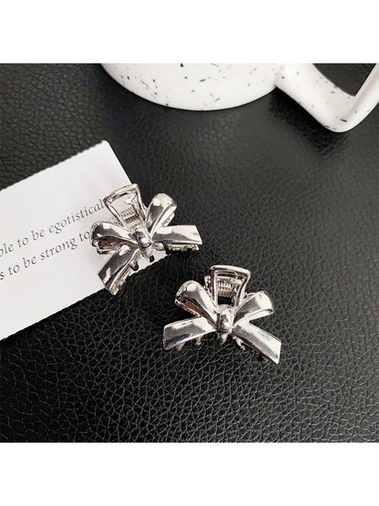 Beau classic bow hair clip worn in long brown hair styled in loose waves